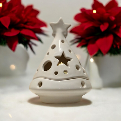 Christmas tree shaped white ceramic candle holder with poinsettias in the background 