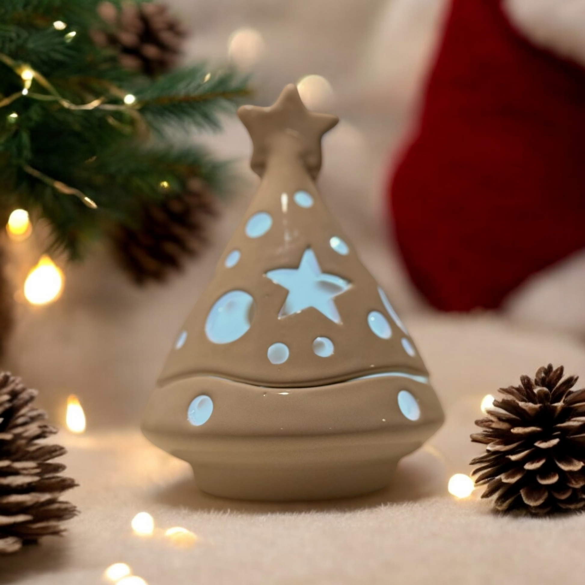 Christmas tree shaped white ceramic candle holder with Christmas decorations in the background