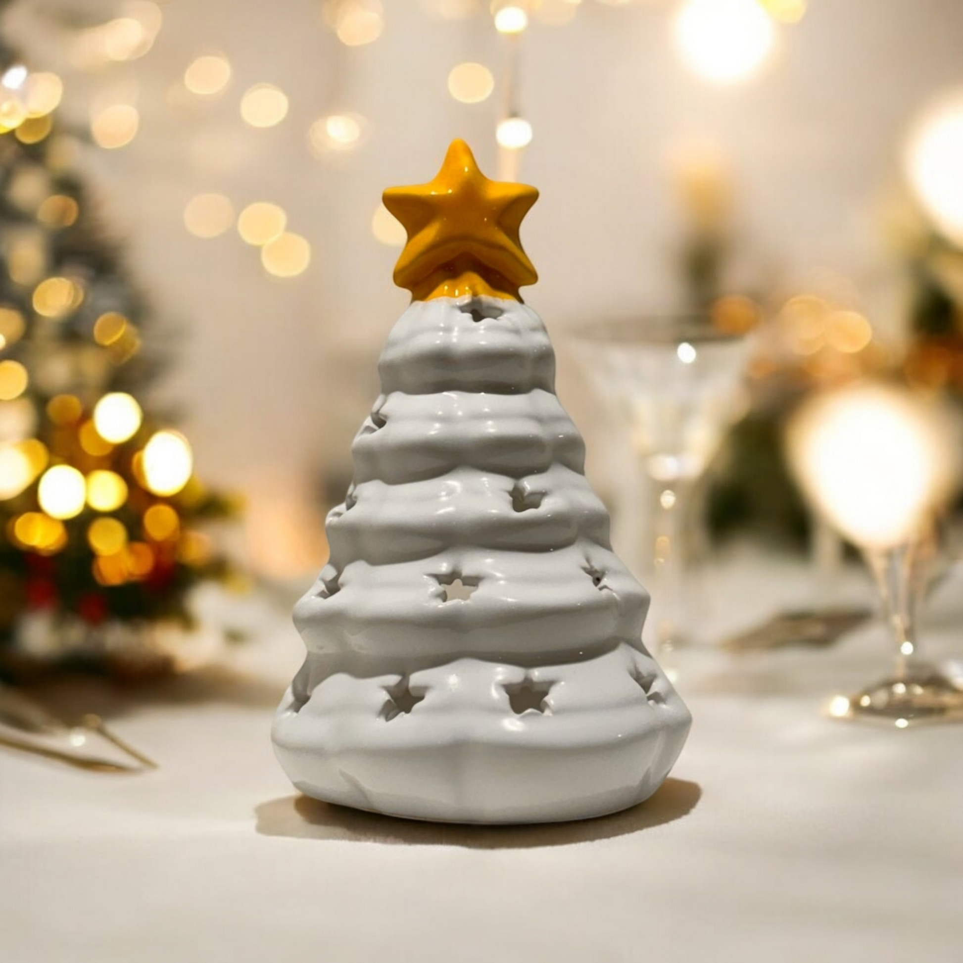 white ceramic Christmas tree shaped candle holder with a yellow star on the top, on a Christmas dinner table